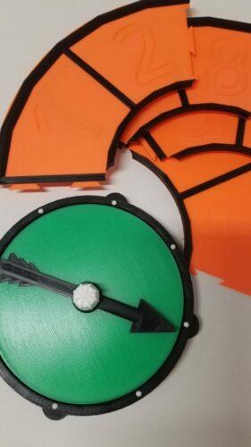 Picture of the game spinner with the additional ring dismantled into its 4 component parts