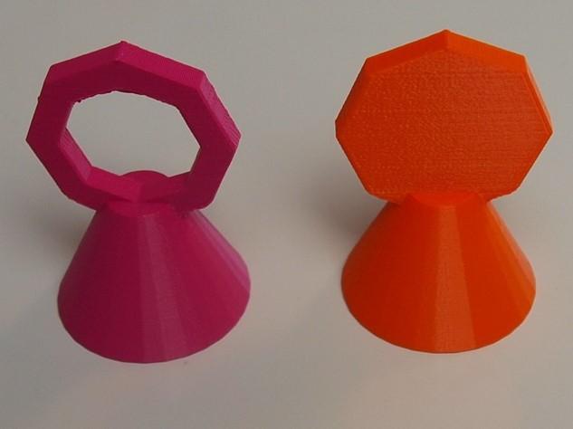 Two game pieces; both variants consist of a cone topped with a octagon. The difference is that one octagon is hollow (it has only a frame) and the other is filled.