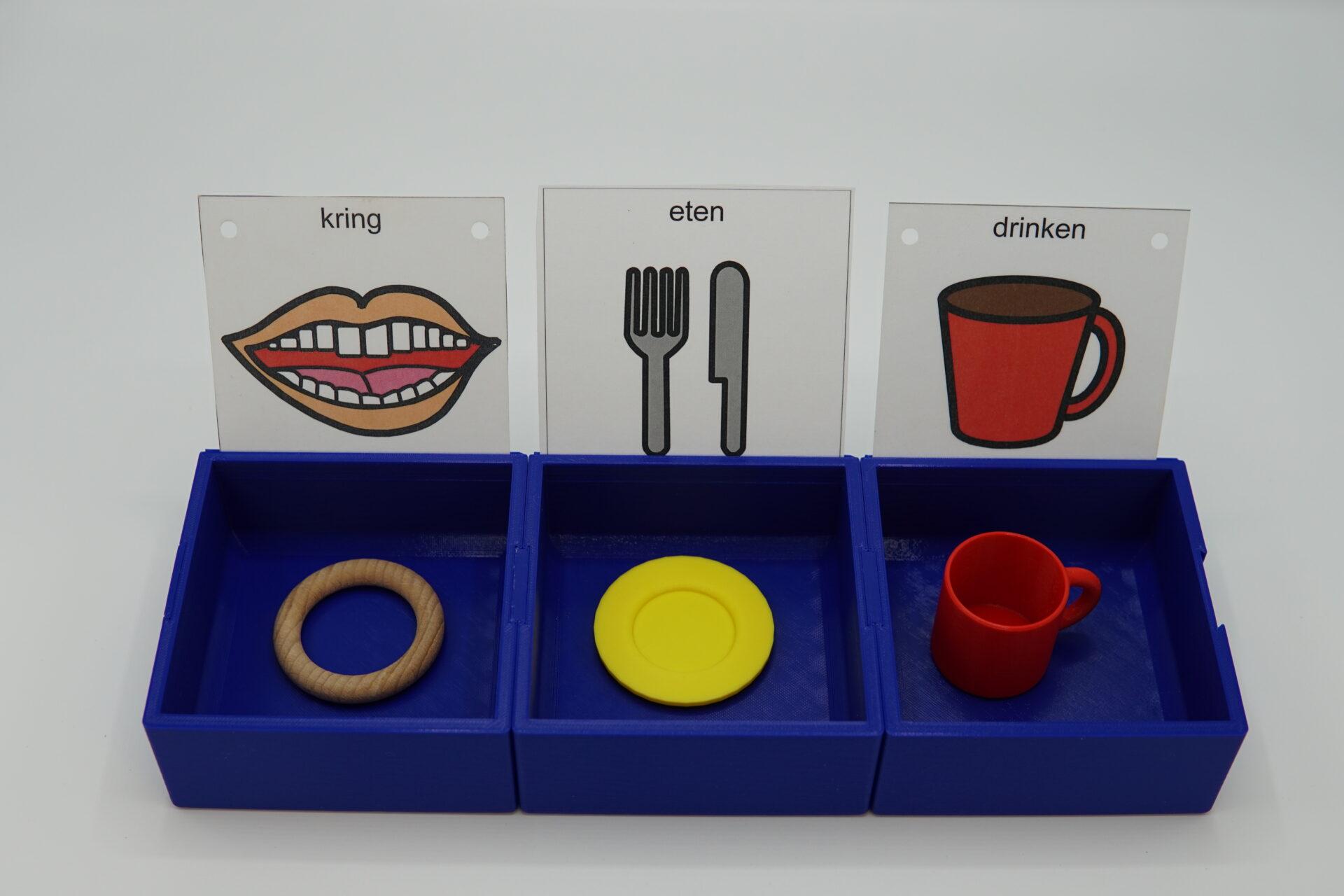 three trays interlocking and each holding objects of reference. cards with symbols are place in trays