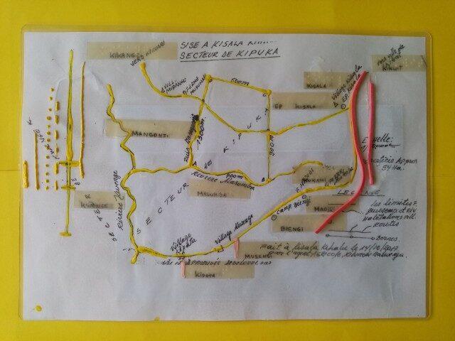 A laminated A4 map with roads and rivers marked with glue. Braille is applied.