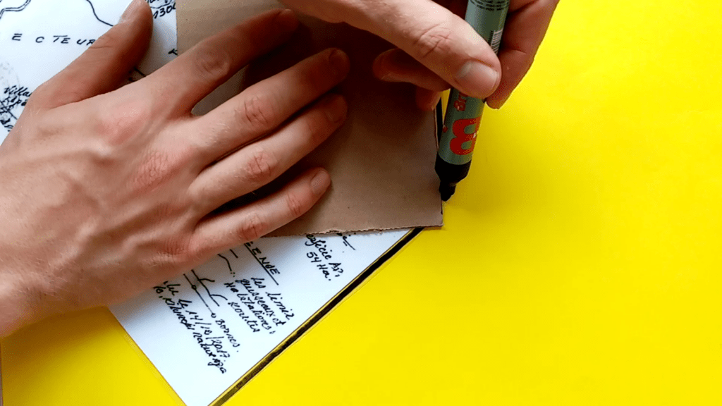 A black permanent marker with a thick tip is used to mark the edge of the laminate map, which increases it's visibility
