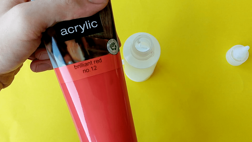 A tube of red acrylic paint is shown next to an open bottle of PVA glue.