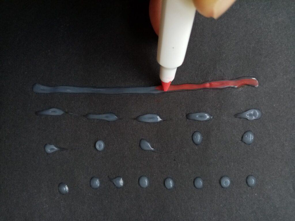 Use a permanent marker to highlight the glue in a colour contrasting with the background