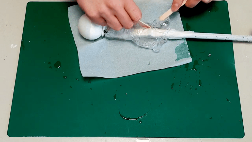 The popsicle sticks are used to remove the softened material