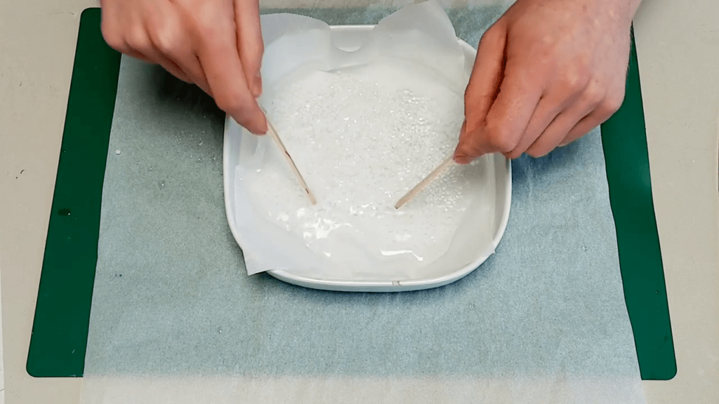 The popsicle sticks are used to evenly distribute the granulates