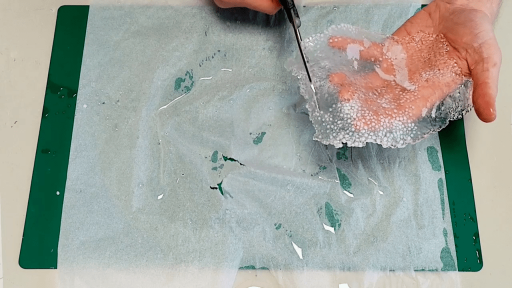 A scissor is used to cut the material into the desired shape.