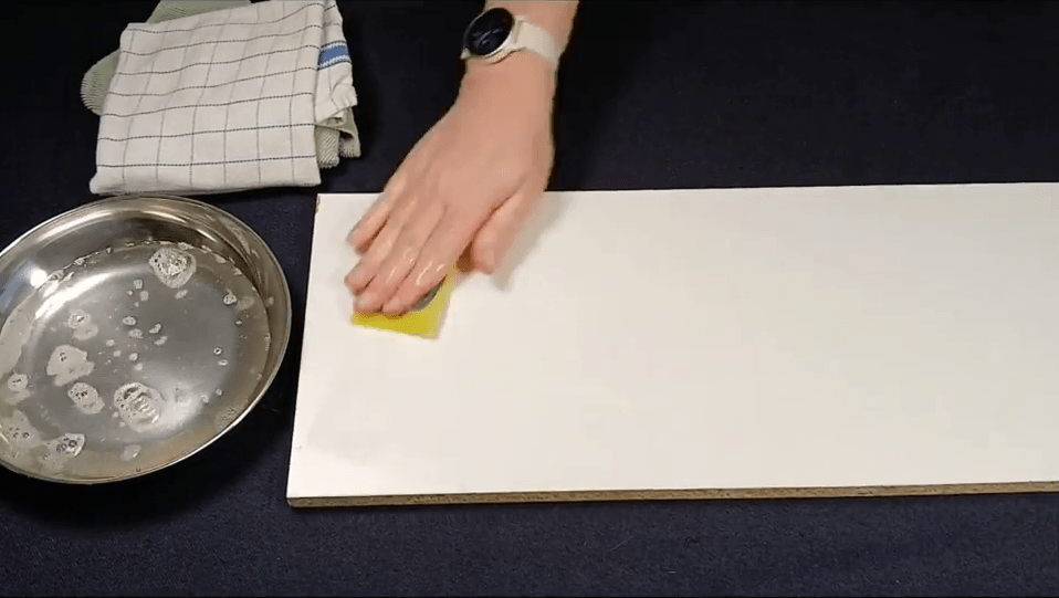 Wiping the shelf with a wet sponge