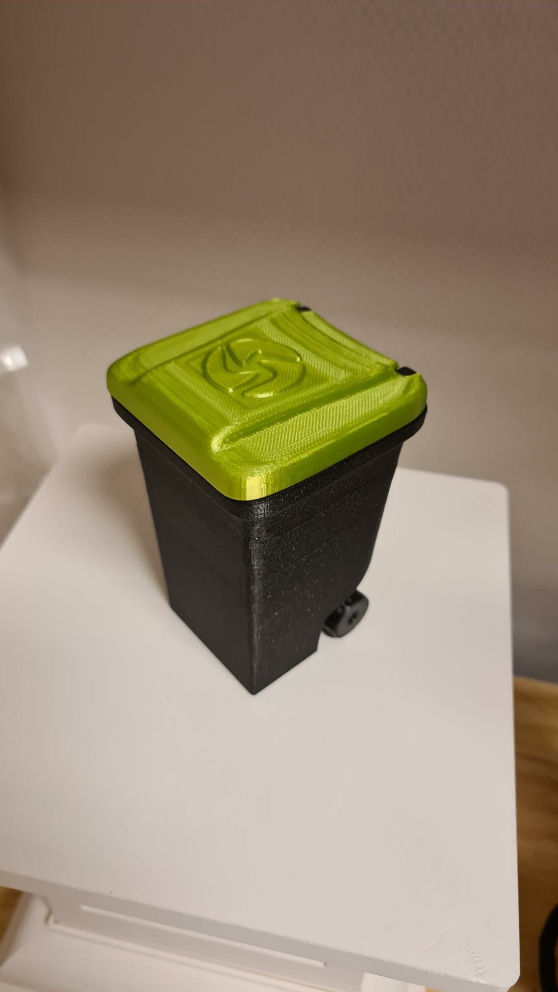 Picture of an example print with two colors. It is a trash can. The body of the trash can is in black, the lid of the trash can is in clear green.
